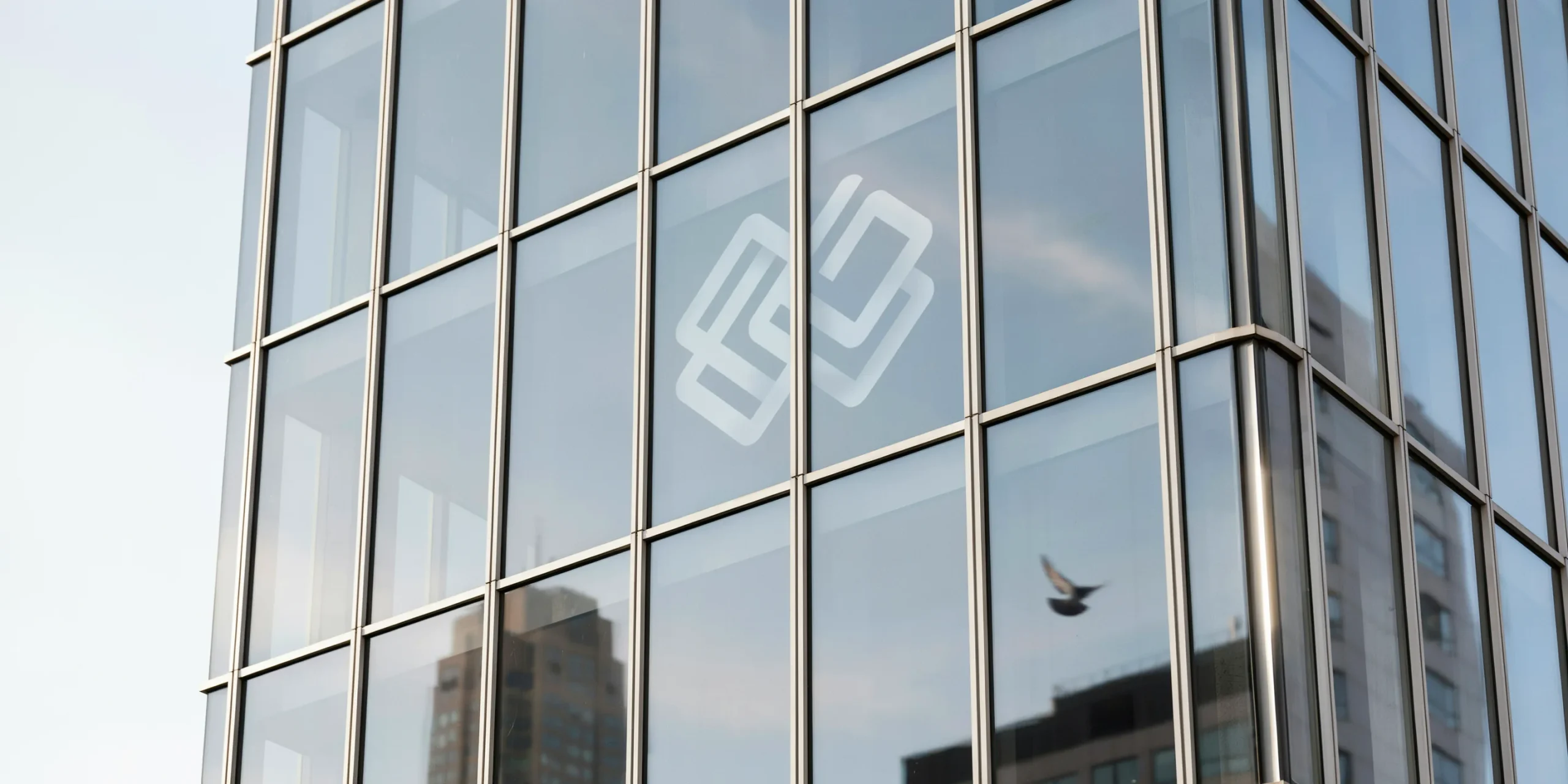Close-up of a glass building facade showcasing corporate logos and transparency.