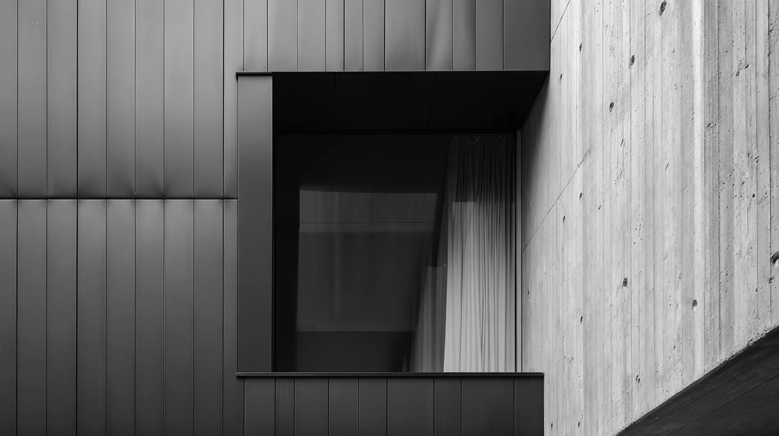 Dark metal cladding, recessed glazing and board-marked concrete meeting on a facade, the material information an AutoCAD drawing does not carry