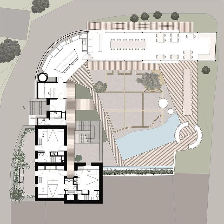 Rendered site plan of a boutique hotel showing the building footprint, courtyard paving, pool and surrounding trees in color
