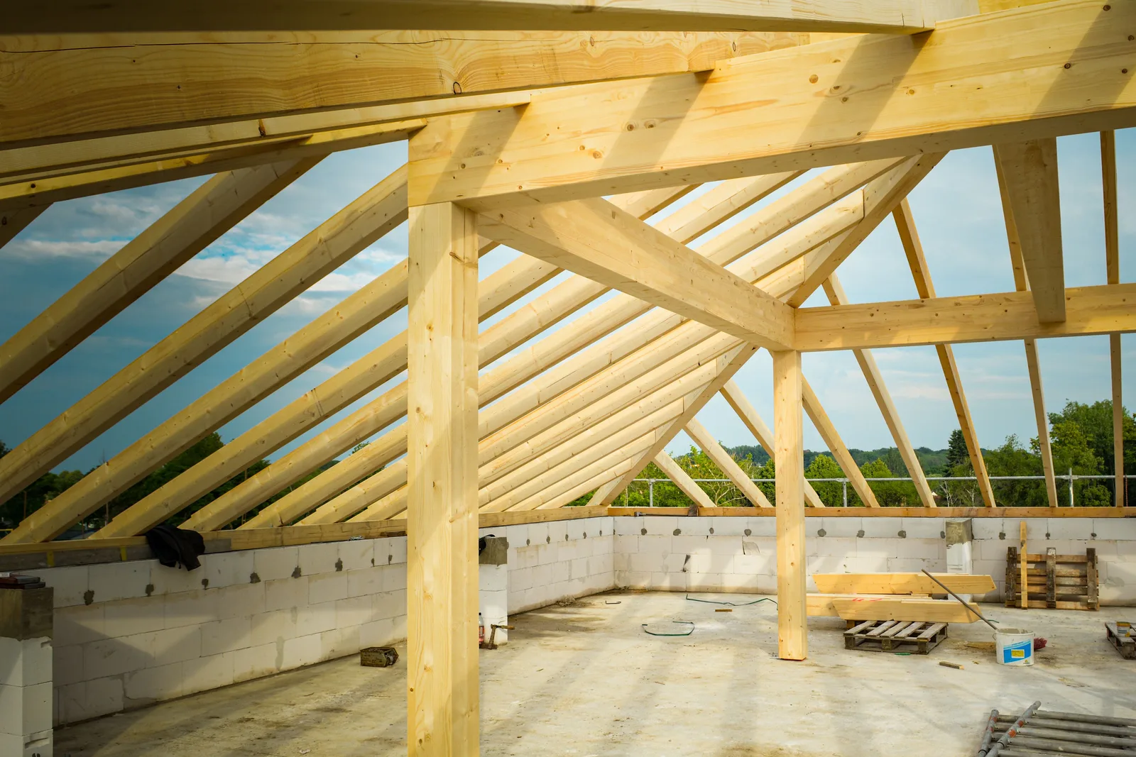 Laminated timber posts and rafters forming a roof frame over a masonry storey on site