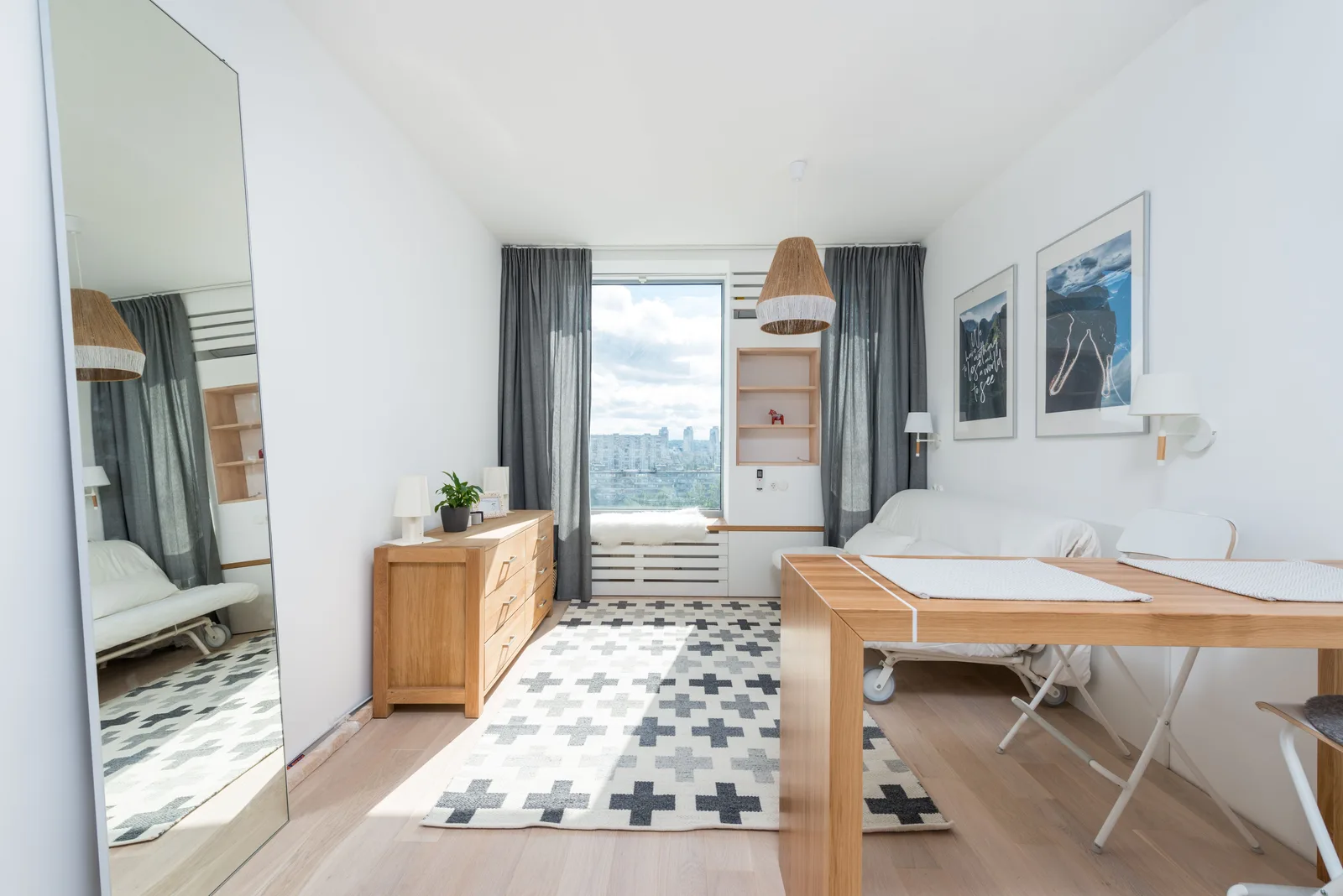 Narrow white room with one continuous pale floor, a tall window at the end and a clear sightline